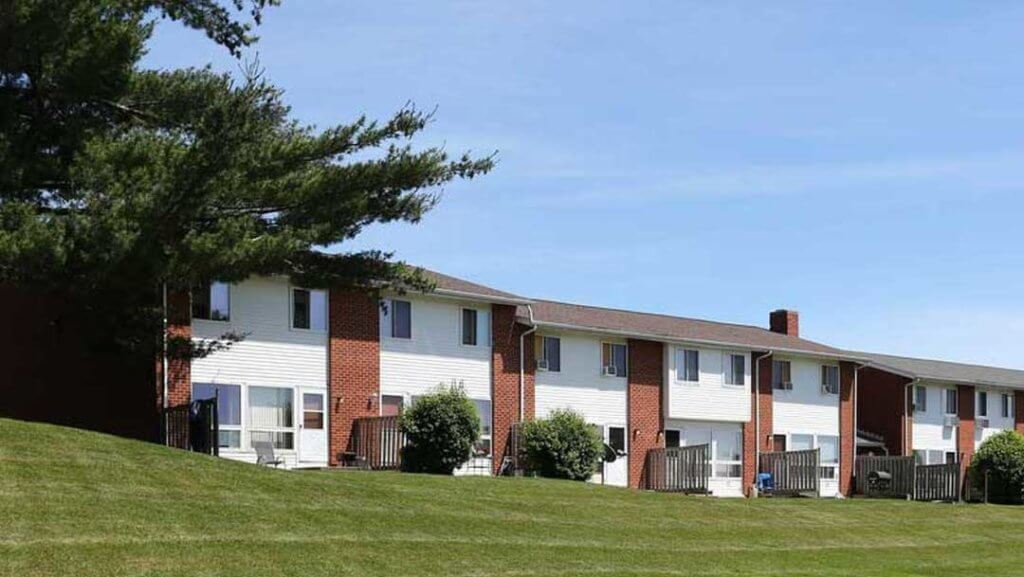 Two story buildings with lots of green space.