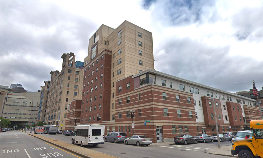 Yellow and red brick building with multiple levels in different sections.