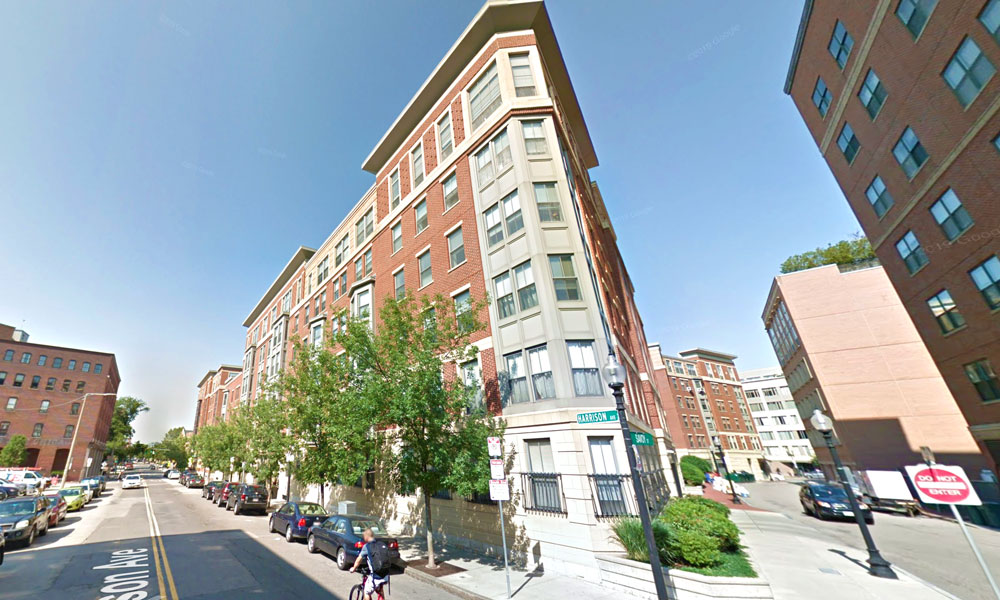 Beautiful brick buildings at the corner of Harrison another street. Tree lined.