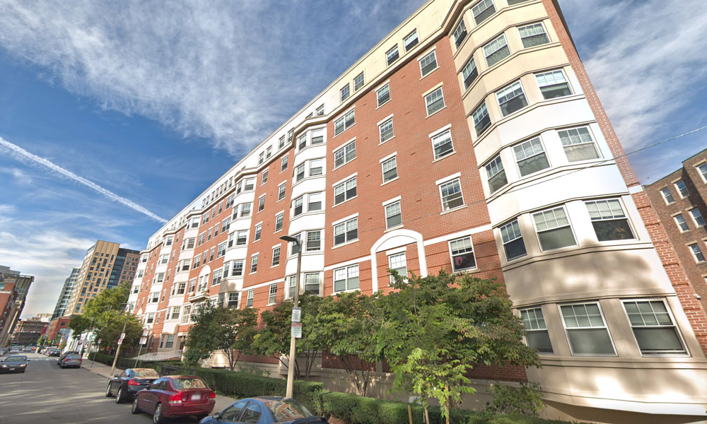 7 story brick building, quite long, with tree lined sidewalks.