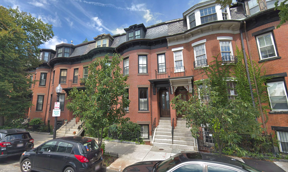 Three or four story brick browstone style buildings with canted bay windows