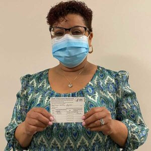 Property Manager holding vaccine card
